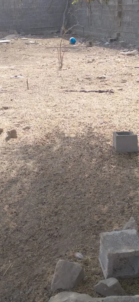 زمین خالی با دیوار بلوکی وسط روستای بنیوار