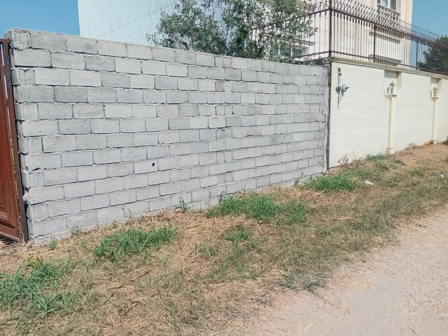 یک قطعه زمین دور دیوار با انباری و دروازه بزرگ